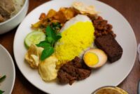 Sajian piring gizi seimbang berisi kombinasi karbohidrat kompleks, protein lokal, dan sayuran segar berwarna-warni yang siap menutrisi tubuh secara optimal.