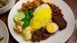 Sajian piring gizi seimbang berisi kombinasi karbohidrat kompleks, protein lokal, dan sayuran segar berwarna-warni yang siap menutrisi tubuh secara optimal.