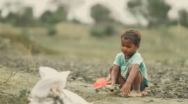 Seorang anak terlihat gembira saat mengeksplorasi tanaman di alam terbuka yang dapat membantu menstimulasi sistem kekebalan tubuhnya.