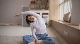 Seorang pekerja mengambil jeda singkat untuk melakukan peregangan ringan di sela jam kerja guna menjaga kelenturan tubuh dan fokus mental.