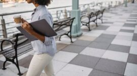 Seorang pekerja profesional meluangkan waktu berjalan kaki santai di taman kota untuk menjaga kebugaran fisik dan kesegaran pikiran di sela rutinitas kerja harian.