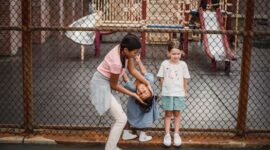 Dua anak kecil tampak gembira saat menjelajahi area rumput dan mengumpulkan dedaunan di sebuah taman kota pada pagi hari. Aktivitas luar ruangan yang bebas membantu mengasah sensori serta ketahanan fisik anak secara alami.