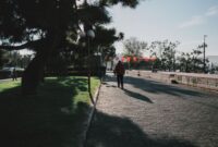Seorang perempuan menikmati udara segar dan paparan sinar matahari pagi di taman kota untuk menjaga keseimbangan ritme sirkadian tubuh.