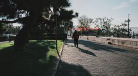Seorang perempuan menikmati udara segar dan paparan sinar matahari pagi di taman kota untuk menjaga keseimbangan ritme sirkadian tubuh.
