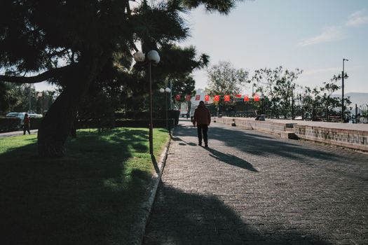 Seorang perempuan menikmati udara segar dan paparan sinar matahari pagi di taman kota untuk menjaga keseimbangan ritme sirkadian tubuh.