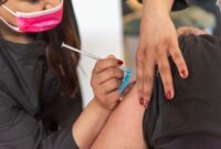 Seorang ibu memberikan dekapan hangat untuk menenangkan buah hatinya saat menerima tindakan imunisasi rutin di fasilitas pelayanan kesehatan masyarakat.