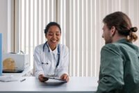 Seorang dokter spesialis sedang mendiskusikan hasil pemeriksaan medis secara mendetail bersama pasien untuk memastikan langkah penanganan yang tepat.