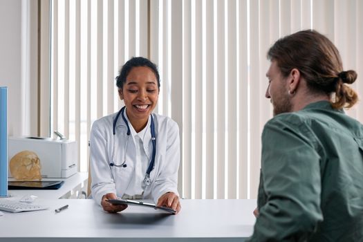 Seorang dokter spesialis sedang mendiskusikan hasil pemeriksaan medis secara mendetail bersama pasien untuk memastikan langkah penanganan yang tepat.