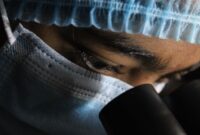 Seorang peneliti medis sedang mengamati visualisasi struktur genetik molekul obat terapi terbaru di dalam laboratorium bioteknologi modern.
