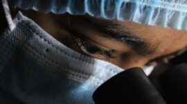 Seorang peneliti medis sedang mengamati visualisasi struktur genetik molekul obat terapi terbaru di dalam laboratorium bioteknologi modern.