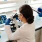 Seorang peneliti medis sedang mengamati sampel sel berbasis rekayasa genetika di dalam laboratorium canggih untuk persiapan prosedur terapi presisi pada pasien penyakit kronis.