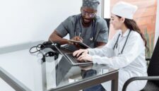 Seorang dokter sedang memberikan konsultasi medis dan penjelasan mendalam mengenai rencana pengobatan kepada pasien di ruang pemeriksaan fasilitas kesehatan.