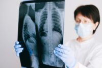 Seorang peneliti medis sedang menganalisis profil keanekaragaman mikrobioma usus dan pola genetik pasien menggunakan visualisasi data digital modern di laboratorium kedokteran presisi.