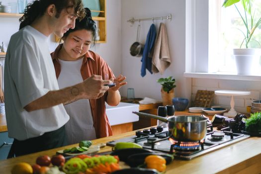 Sepasang suami istri sedang menyiapkan hidangan sehat bersama di dapur rumah untuk mendukung pola hidup seimbang dan kesuburan reproduksi keluarga.