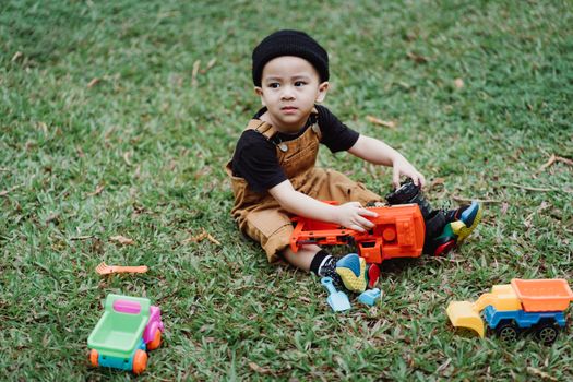 Seorang anak balita sedang asyik bermain tanah dan mengeksplorasi tanaman di halaman terbuka. Aktivitas alami ini berperan penting dalam melatih motorik halus serta memicu rasa ingin tahu sejak dini.