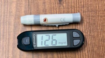 Seseorang sedang memeriksa data metabolisme harian melalui aplikasi ponsel pintar yang terhubung dengan sensor kesehatan personal.