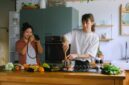Sepasang suami istri membagikan momen kebersamaan saat menyiapkan makanan bernutrisi tinggi di dapur rumah mereka sebagai bentuk komitmen menjaga kebugaran tubuh.