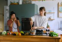Sepasang suami istri membagikan momen kebersamaan saat menyiapkan makanan bernutrisi tinggi di dapur rumah mereka sebagai bentuk komitmen menjaga kebugaran tubuh.