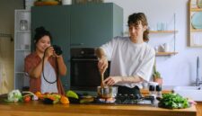 Sepasang suami istri membagikan momen kebersamaan saat menyiapkan makanan bernutrisi tinggi di dapur rumah mereka sebagai bentuk komitmen menjaga kebugaran tubuh.