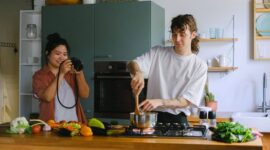 Sepasang suami istri membagikan momen kebersamaan saat menyiapkan makanan bernutrisi tinggi di dapur rumah mereka sebagai bentuk komitmen menjaga kebugaran tubuh.