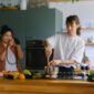 Sepasang suami istri membagikan momen kebersamaan saat menyiapkan makanan bernutrisi tinggi di dapur rumah mereka sebagai bentuk komitmen menjaga kebugaran tubuh.