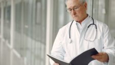 Seorang dokter ahli sedang menjelaskan hasil analisis pemetaan mikrobioma dan risiko genetik pasien menggunakan visualisasi data digital interaktif di klinik kedokteran presisi.