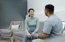 Pasangan suami istri sedang berkonsultasi secara terbuka dengan dokter spesialis untuk mendiskusikan perencanaan kesehatan reproduksi keluarga di klinik medis modern.