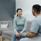 Pasangan suami istri sedang berkonsultasi secara terbuka dengan dokter spesialis untuk mendiskusikan perencanaan kesehatan reproduksi keluarga di klinik medis modern.