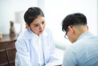 Seorang dokter spesialis sedang memberikan konsultasi mendalam mengenai diagnosis medis yang akurat kepada pasien di sebuah klinik modern.