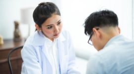 Seorang dokter spesialis sedang memberikan konsultasi mendalam mengenai diagnosis medis yang akurat kepada pasien di sebuah klinik modern.
