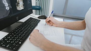Seorang dokter spesialis sedang menganalisis data biologis dan profil mikrobioma pasien menggunakan antarmuka digital berbasis kecerdasan buatan untuk merancang program kesehatan terpersonalisasi.