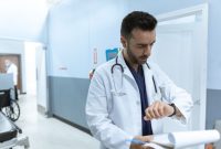 Seorang dokter sedang meneliti hasil uji laboratorium bersama pasien untuk menentukan penanganan medis yang paling presisi. Penjelasan terperinci mengenai kondisi kesehatan membantu pasien mengambil keputusan perawatan dengan tenang.