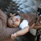 Seorang dokter spesialis anak memberikan suntikan vaksinasi dasar kepada bayi yang berada dalam dekapan hangat ibunya di klinik kesehatan.