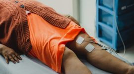 Seseorang sedang menjalani sesi terapi fotobiomodulasi dan gelombang suara di sebuah ruang perawatan kesehatan modern untuk memulihkan energi seluler serta meredakan stres.
