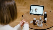 Seorang pasien sedang berkonsultasi secara virtual dengan dokter spesialis melalui layar telepon pintar untuk mendapatkan pertolongan medis awal yang praktis dari rumah.